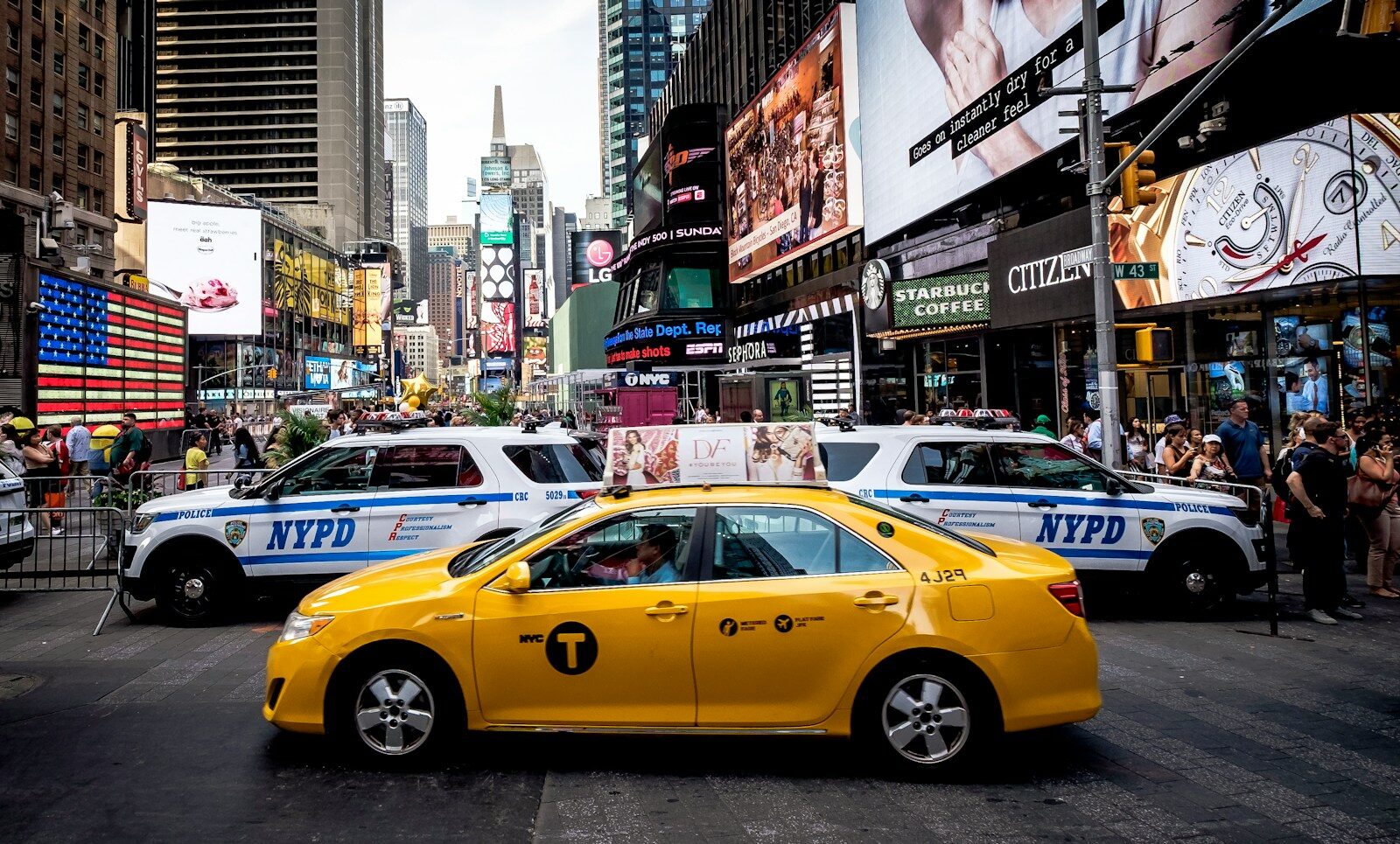 yellow sedan beside police cars